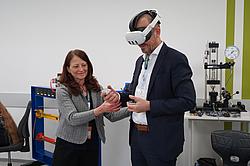 Zwei Personen probieren gemeinsam eine VR-Anwendung aus, eine unterstützt bei der Bedienung.