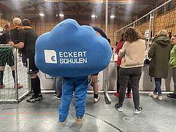 Eckert-Maskottchen EDDI steht am Spielfeldrand und verfolgt das Benefizturnier in der Mehrzweckhalle Ramspau.