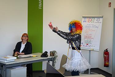 Workshop mit humorvoller Präsentation und Flipchart im Unterrichtsraum.