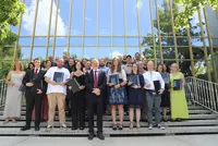 Gemeinsam ausgezeichnet: Die Preisträgerinnen und Preisträger der Eckert Schulen Große Gruppe von Personen steht auf der Treppe vor dem verglasten Gebäude der Eckert Schulen. Viele halten Urkunden und Glastrophäen in den Händen. Die Personen lächeln in die Kamera.