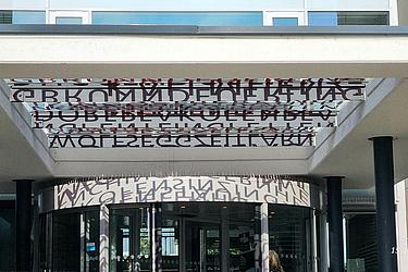 Eingangsbereich des Landratsamtes Regensburg mit künstlerisch gestaltetem Schriftzug über der Drehtür.