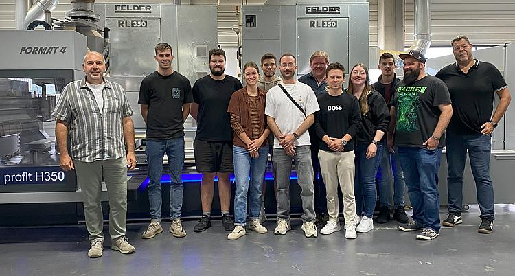 Gruppenbild von Teilnehmern der Holztechnik-Exkursion vor einer CNC-Maschine bei der Felder Group.