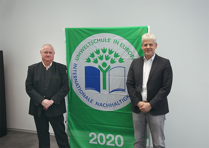 Markus Johannes Zimmermann (Geschäftsführer und Schulleiter der Dr. Eckert Akademie, rechts) und Gerald Saule (Head of Vocational Training International und Umweltbeauftragter) nahmen die traditionell mit der Auszeichnung verliehene Flagge am Campus Regen Markus Johannes Zimmermann (Geschäftsführer und Schulleiter der Dr. Eckert Akademie, rechts) und Gerald Saule (Head of Vocational Training International und Umweltbeauftragter) nahmen die traditionell mit der Auszeichnung verliehene Flagge am Campus Regenstauf entgegen.